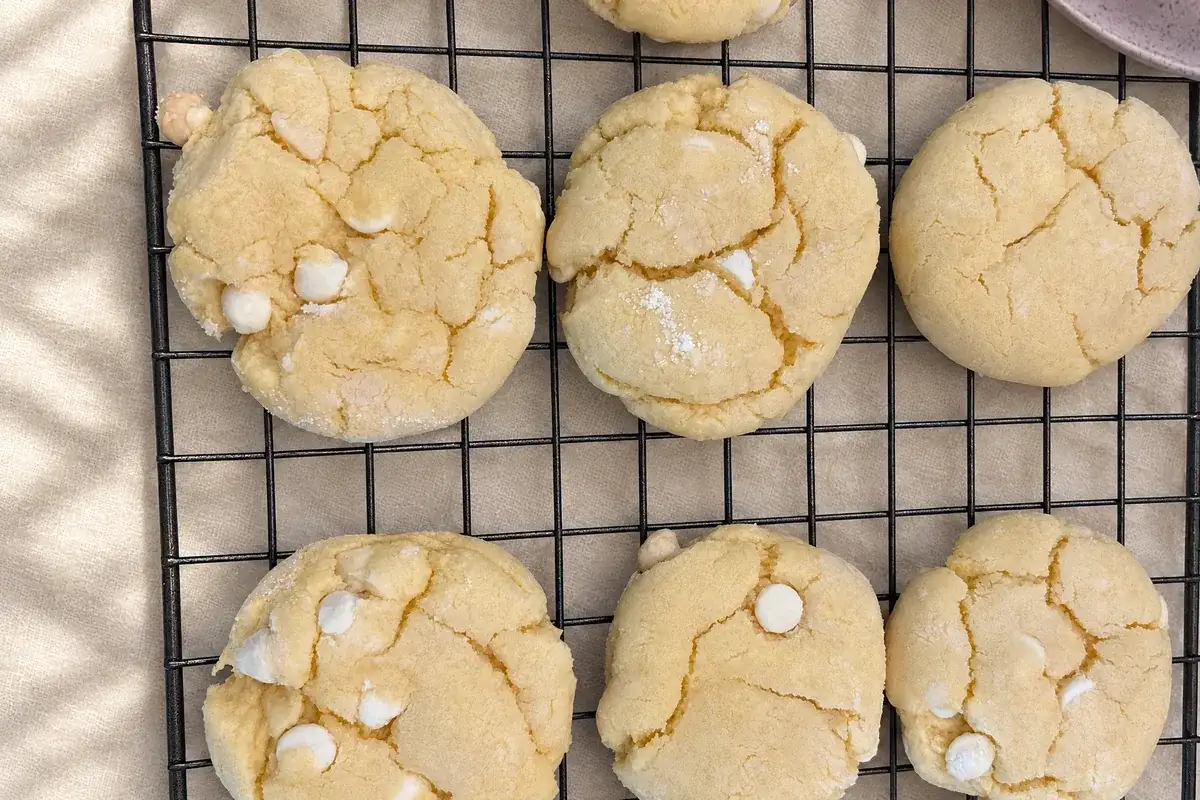 A wire cooling rack of white-chip cookies on cream linen in the Sugar Plum kitchen